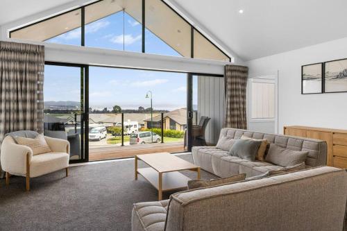 a living room with a couch and chairs and a large window at Peaceful Taupo Escape With King Suite and Comfort in Taupo