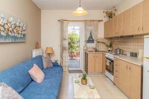 a living room with a blue couch and a kitchen at Estia cozy apartment in Argostoli