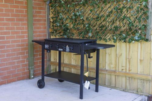 a black barbecue cart sitting in front of a fence at Brand New Backyard Guest House in Werribee CBD in Werribee