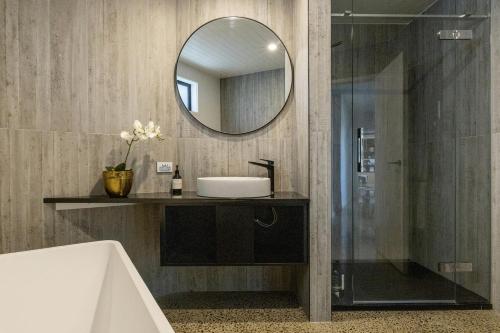 a bathroom with a sink and a mirror at Elevated Taupo Hideaway With Views and Designer Comfort in Taupo