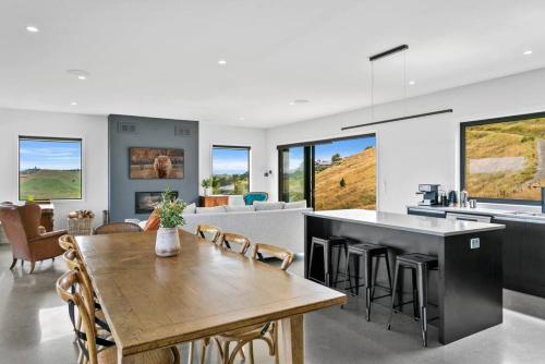 Una cocina y una sala de estar con una mesa y sillas de madera. en Peaceful Luxury Retreat with Lake Views and Spa Pool, en Taupo