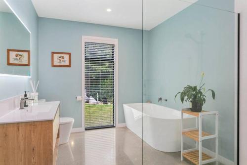 Un baño con bañera, inodoro y lavabo. en Peaceful Luxury Retreat with Lake Views and Spa Pool, en Taupo