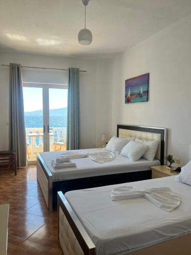 two beds in a hotel room with a window at Rock Star-Pllakat in Sarandë