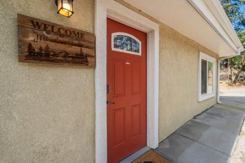a red door on a building with a welcome sign at Mountain Studio Cozy Escape with Stunning Views in Cascade-Chipita Park