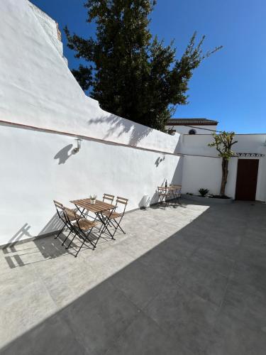 een patio met stoelen en een tafel naast een muur bij Casa Peñas 2 in Ronda