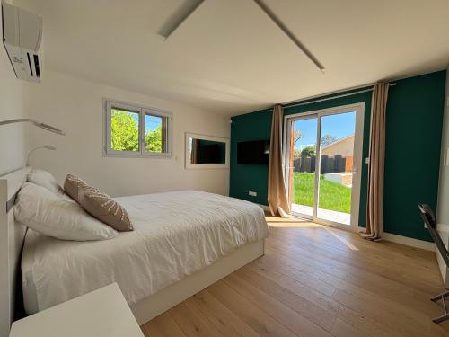 a bedroom with a bed and a sliding glass door at Villa Karasse in Lège-Cap-Ferret