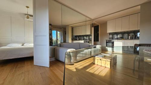 un salon avec un lit et une table en verre dans l'établissement Grand appartement avec vue sur la fontaine de la Rotonde, à Aix-en-Provence