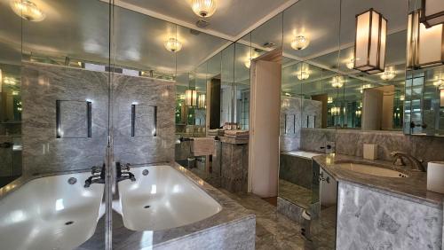 une grande salle de bain avec une baignoire et un lavabo dans l'établissement Grand appartement avec vue sur la fontaine de la Rotonde, à Aix-en-Provence