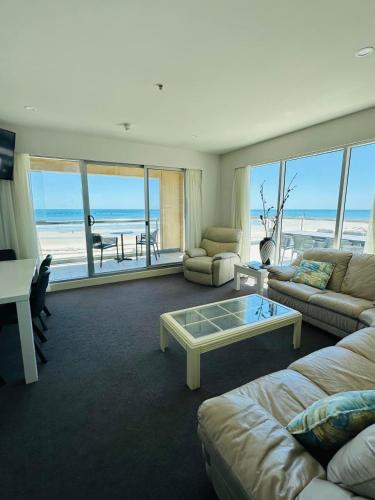 a living room with a couch and a coffee table at Beachfront Serenity Glenelg in Glenelg
