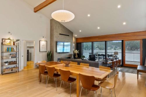 KamilcheにあるLakefront Luxury Stunning Views Dock Hot Tubのテーブルと椅子のあるダイニングルームとリビングルーム