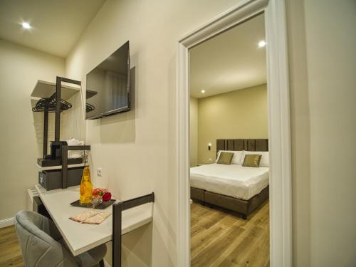 a bedroom with a bed and a table and a mirror at Gioia Guest House in Ciampino