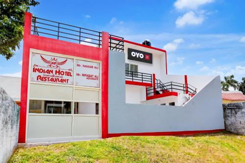 a red and white building with a gate at Indian Hotel in Bareilly