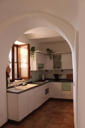 a kitchen with white cabinets and an archway at A BeautifuL Terrace on Paradise Imperia - by HOST4U in Montegrazie