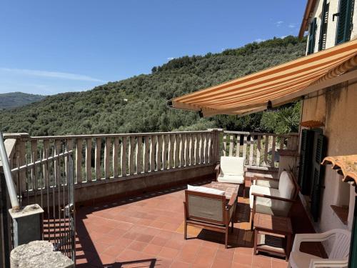a balcony with a table and chairs and an umbrella at A BeautifuL Terrace on Paradise Imperia - by HOST4U in Montegrazie