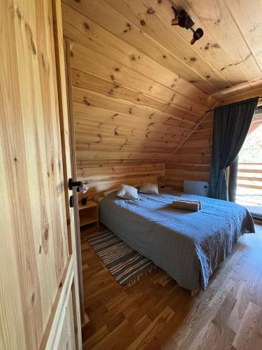a bedroom with a bed in a wooden cabin at Chatka nad Jeziorem Czostków JustChill in Czostków