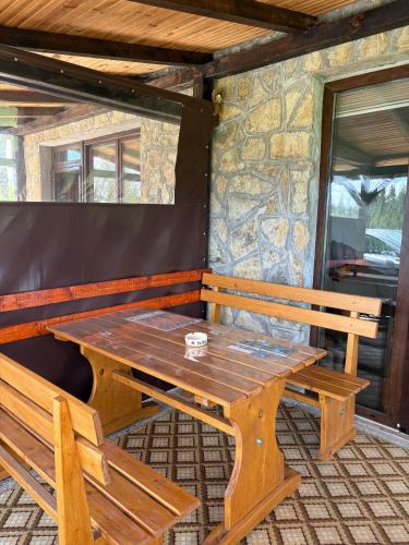 a wooden table and two benches in a room at Vila Trtović in Nova Varoš