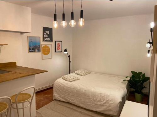 une chambre avec un lit, une table et des chaises dans l'établissement Studio 9 Trinité - Hypercentre Toulouse, Accueil H24 et Wi-Fi, à Toulouse