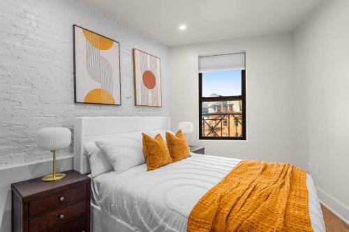 een witte slaapkamer met een bed en een raam bij Prime NYC Location 4BR Spacious Haven in New York