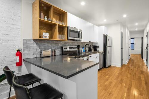een keuken met een aanrecht en een koelkast bij Prime NYC Location 4BR Spacious Haven in New York
