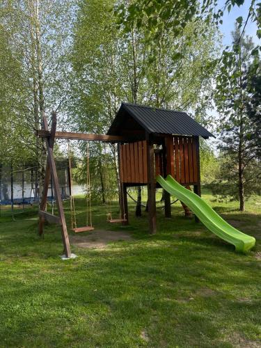 a playground with a green slide in a park at Перлина Буковини in Lipovany