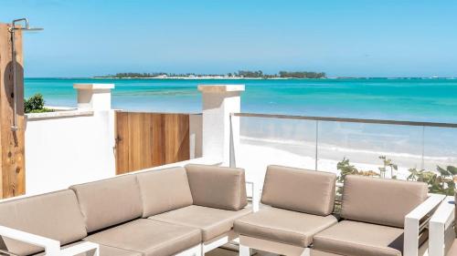 a living room with a couch and a view of the beach at Garden Villa Condo at ONE Cable Beach in Nassau