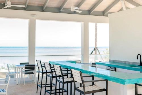 a beach house with a blue counter and chairs at Garden Villa Condo at ONE Cable Beach in Nassau