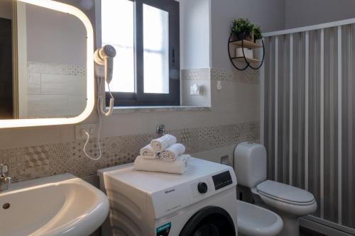 a bathroom with a sink and a washing machine at Quirin's Apartments in Taormina