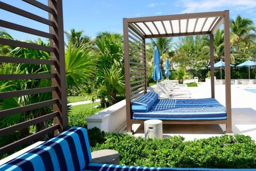 a group of blue chairs under a gazebo at One bedroom condo at ONE Cable Beach in Nassau