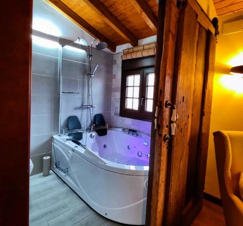 a large bath tub in a bathroom with a window at Casa Rural La Genciana VALMALA in Valmala