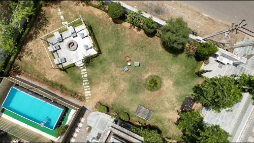 an aerial view of a yard with a house and a pool at Lush Green Retreat Private Pool & Garden Villa, Jaipur in Jaipur