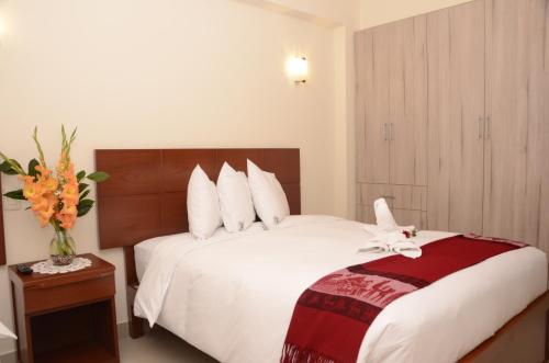 a hotel room with a bed with a flower on it at Aqua Hotel Cusco in Cusco