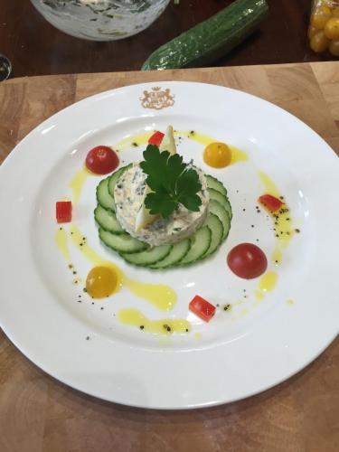 a white plate with some food on a table at The Clarendon Country Pub with rooms in Grassington
