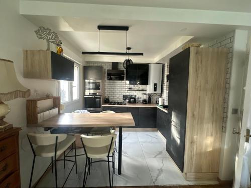 une cuisine avec une table en bois et quelques chaises dans l'établissement Centre ville, au Mans