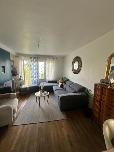 ein Wohnzimmer mit einem blauen Sofa und einem Tisch in der Unterkunft Centre ville in Le Mans