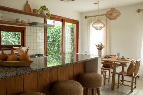 a kitchen with a counter with a table and chairs at Casa Cajú in Cruz