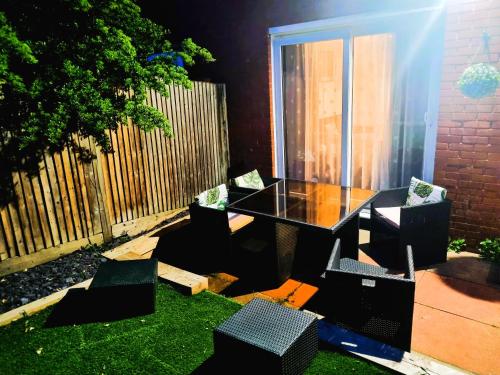 a table and chairs in a yard with a fence at 3bed 2bath House-Free Parking-Fast WiFi-Garden-Entire Home-2mins from Train Station-Sleeps 6 in London