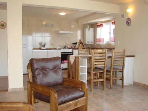 een keuken met een stoel en een keuken met een tafel bij MaDiYa Departamentos in Bariloche