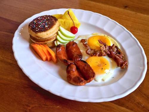 a white plate with breakfast foods on a table at Hotel y Restaurante El Peregrino in Flores