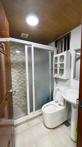 a bathroom with a shower and a toilet and a sink at WPY Condotel in Baguio
