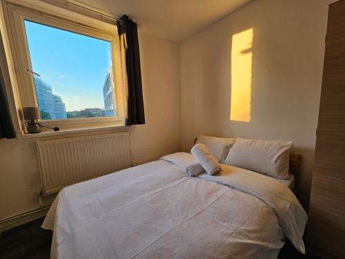 a bedroom with a bed with a large window at Wapping Stay in London