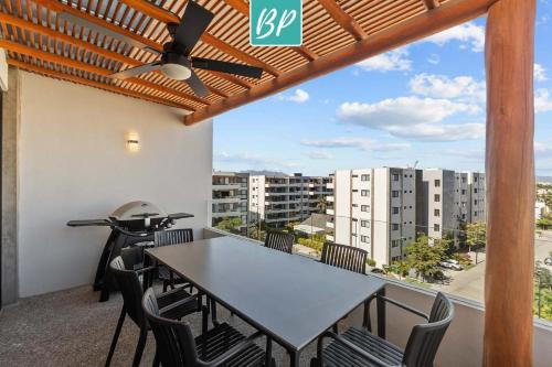 ヌエボ・バジャルタにあるPuertArena Nuevo Nayarit - Modern Comfort Near the Beachの街の景色を望むバルコニーに置かれたテーブルと椅子