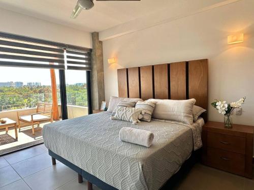 a bedroom with a large bed and a balcony at Puertarena in Nuevo Vallarta