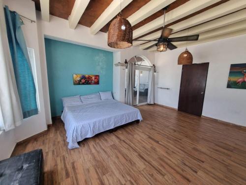 a bedroom with a bed and a ceiling fan at Casa Columpios, con alberca a pasos de la playa in Chuburná
