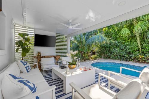 a living room with a pool and a table at New! Luxurious Villa with Pool in West Palm Beach in Ibis Isle