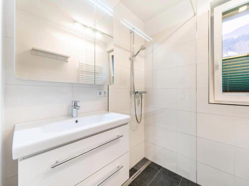 a white bathroom with a sink and a shower at Le Soleil in Bruck an der Großglocknerstraße