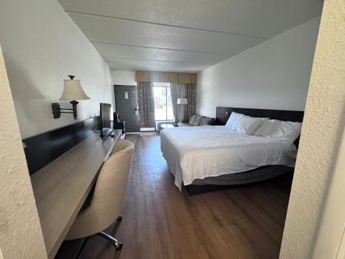 a hotel room with a bed and a desk with a desk at Travel Inn - Lugoff in Lugoff