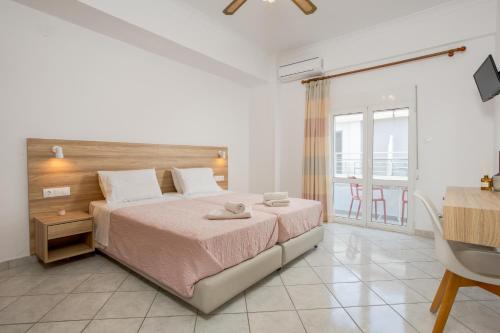 a bedroom with a large bed and a balcony at Eftihia Studios Paleochora in Palaiochóra