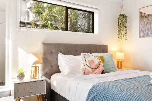 a bedroom with a bed and a window at Coastal Garden Family Hideaway in Auckland