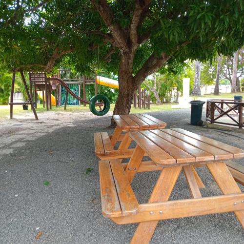 a wooden picnic table next to a tree in a park at Relaxing Suite Coronado, Panamá in Chame