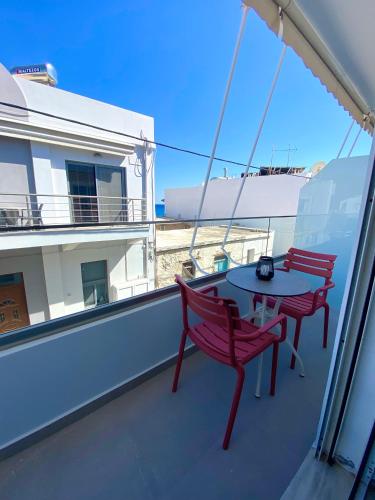 two red chairs and a table on a balcony at Eftihia Studios Paleochora in Palaiochóra